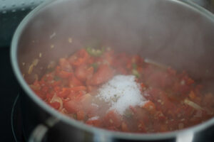 Gewürze und Tomaten dazugeben